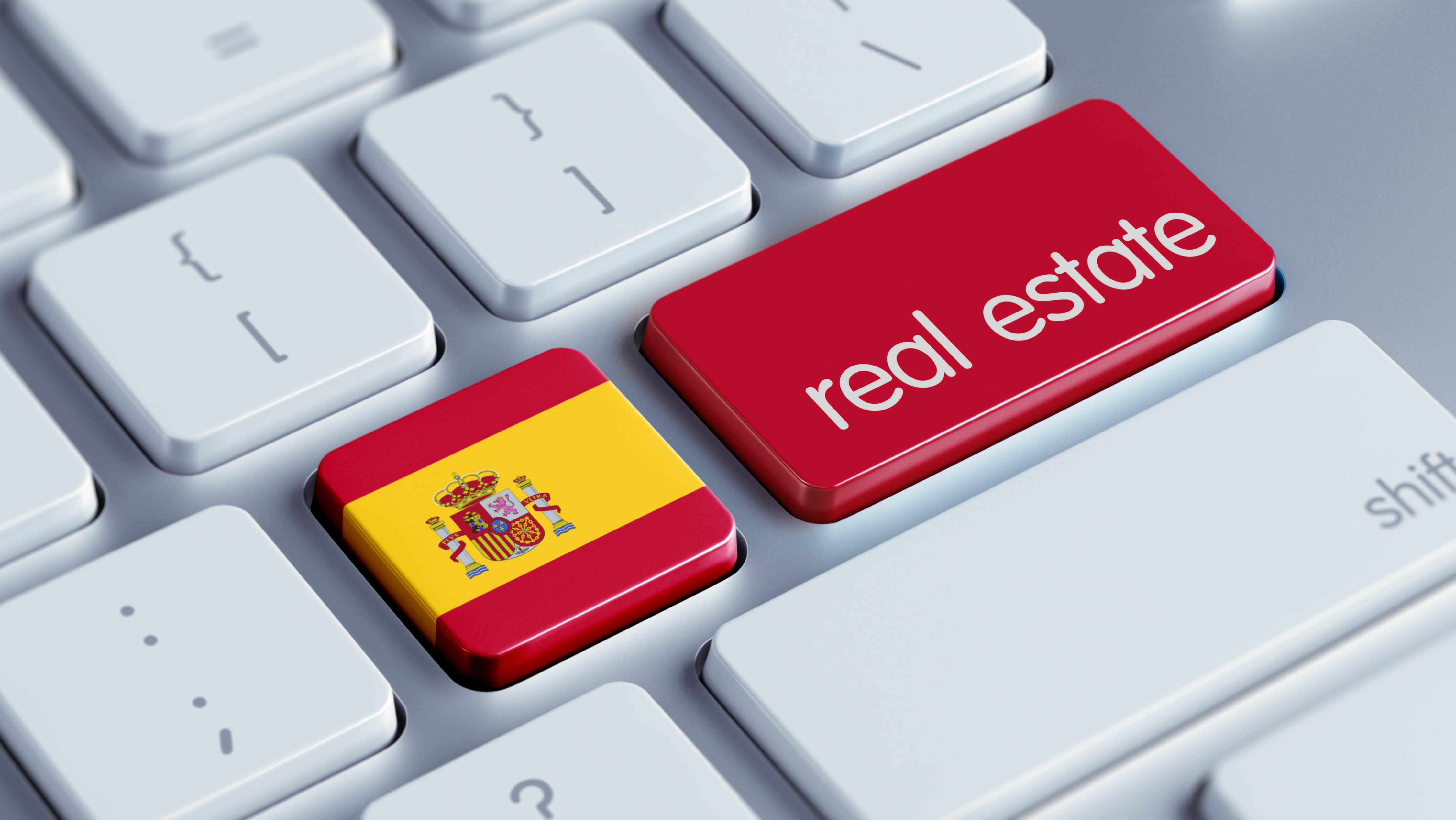 一種計算機鍵盤，其鍵裝飾有西班牙國旗，旁邊是寫著“房地產”的鍵。