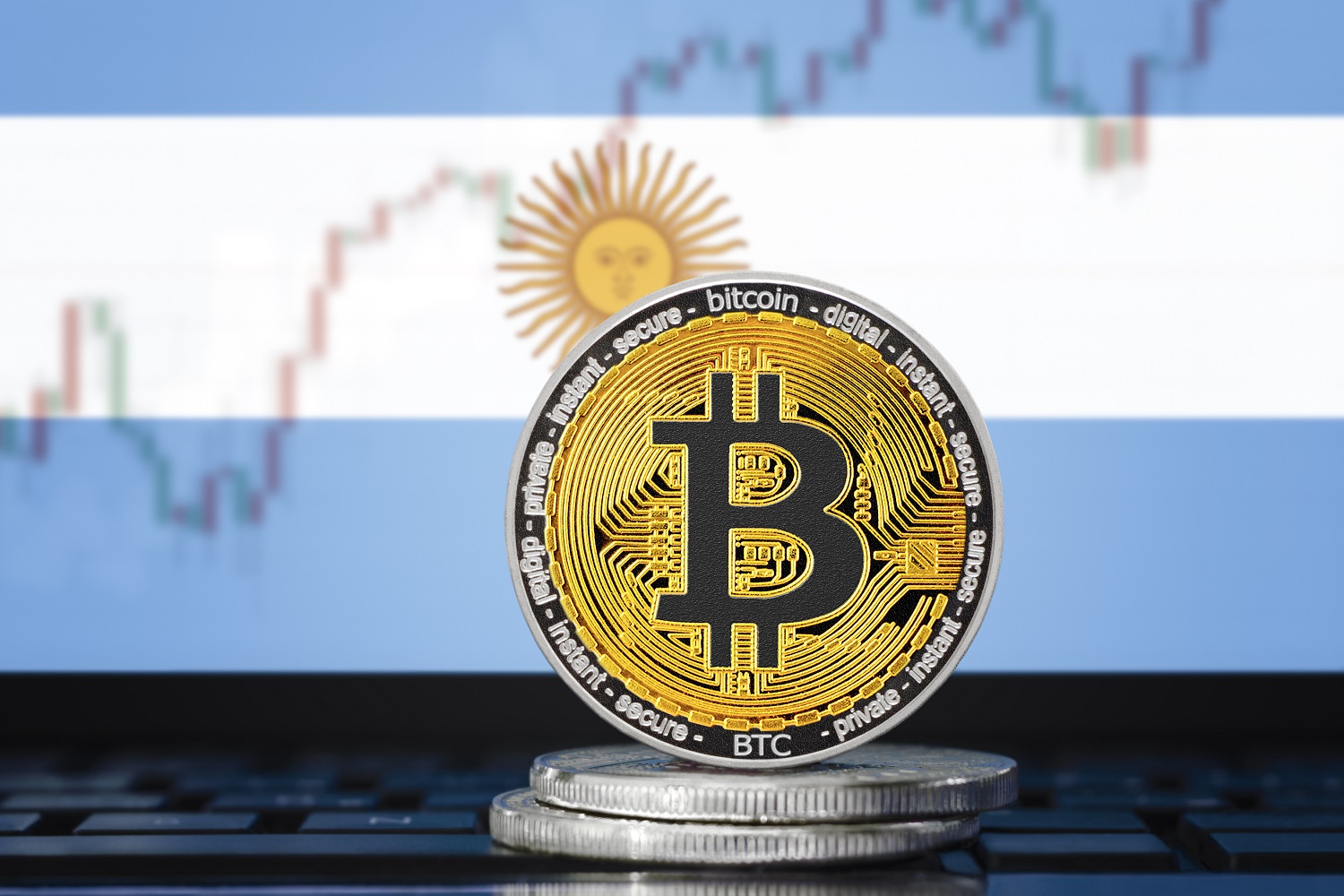 Arjantin bayrağının arka planında Bitcoin'i temsil eden metal jetonlar ve bir fiyat tablosu.
