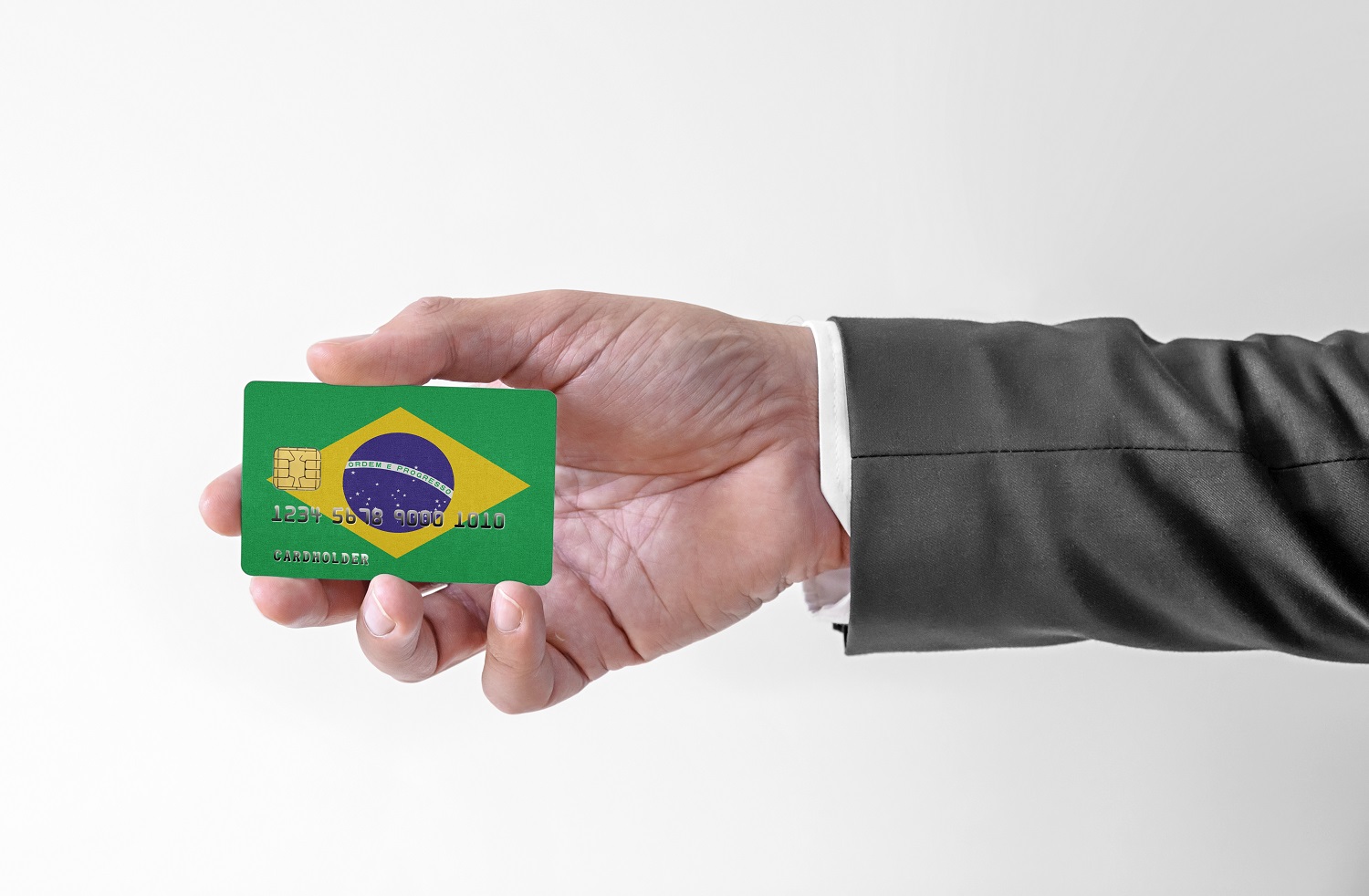 Bir adamın elinde Brezilya bayrağının renkleriyle süslenmiş plastik bir kredi kartı var.